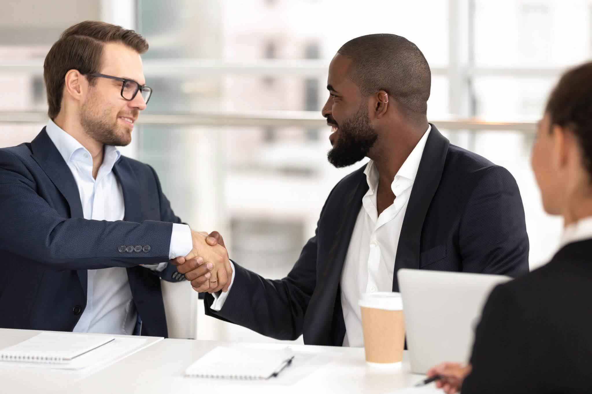 Two businessmen shaking hands after a dental practice valuation