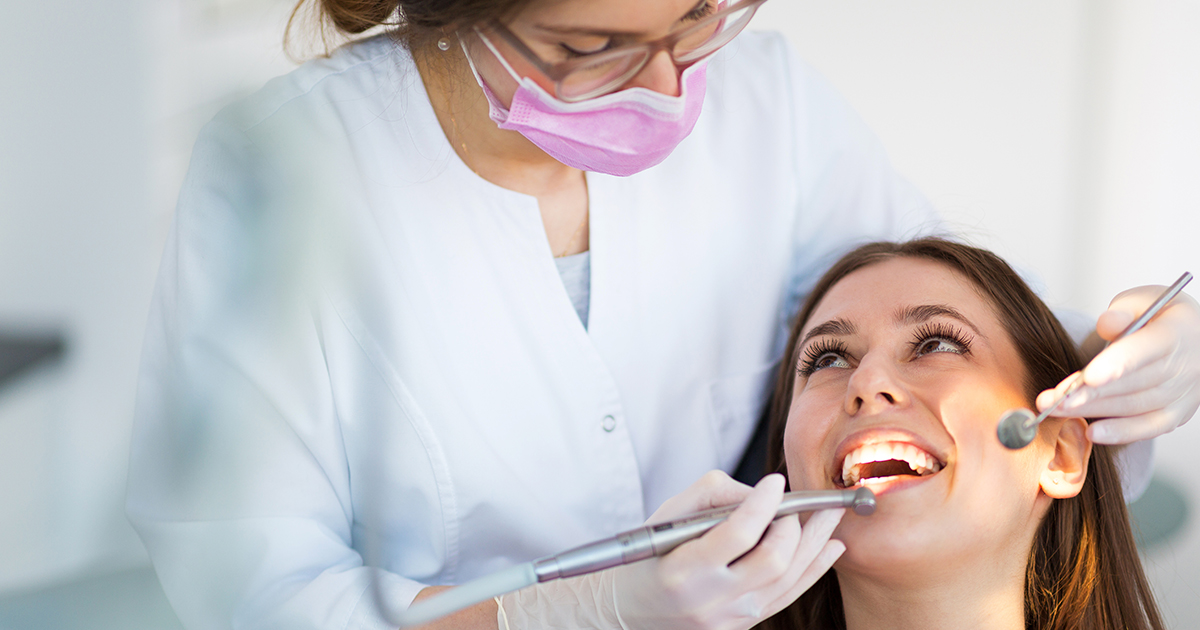 Young dentist performing a dental check-up on a patient. 