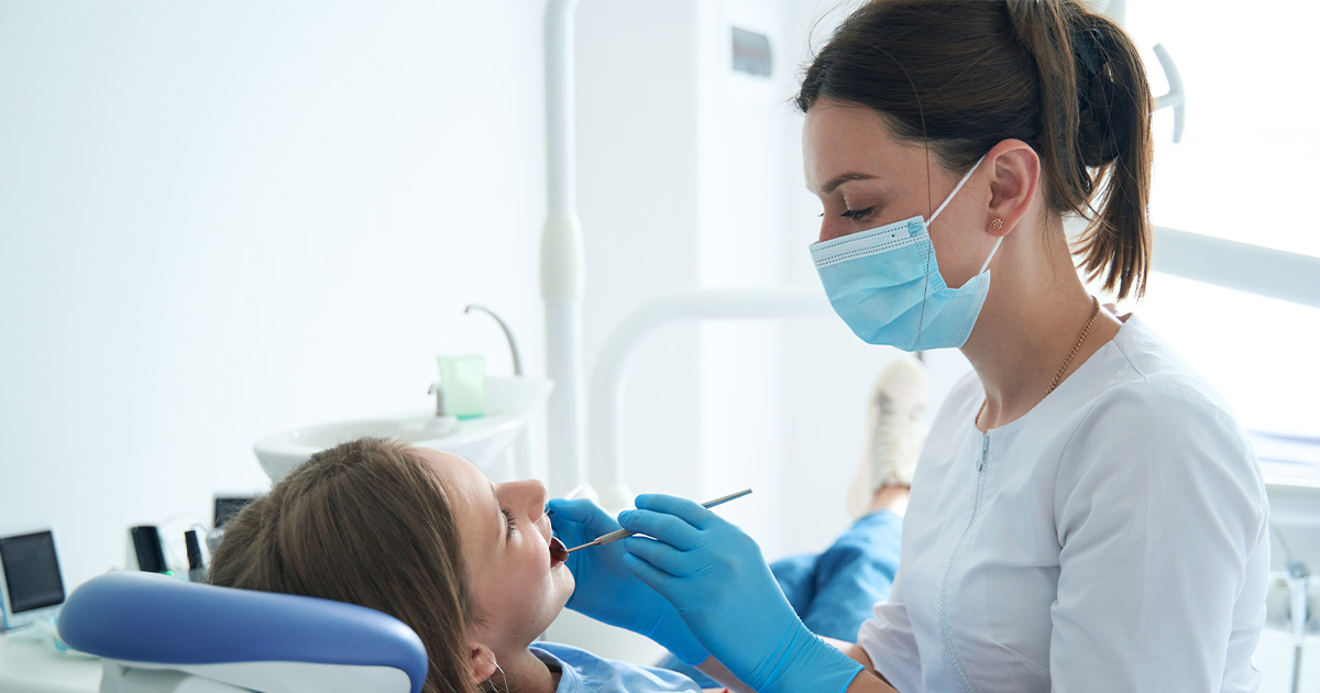 A young dentist performing a procedure on a patient.
