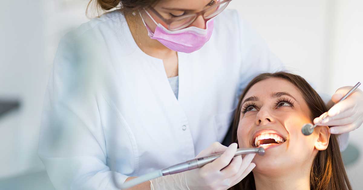 Young dentist performing a dental check-up on a patient.