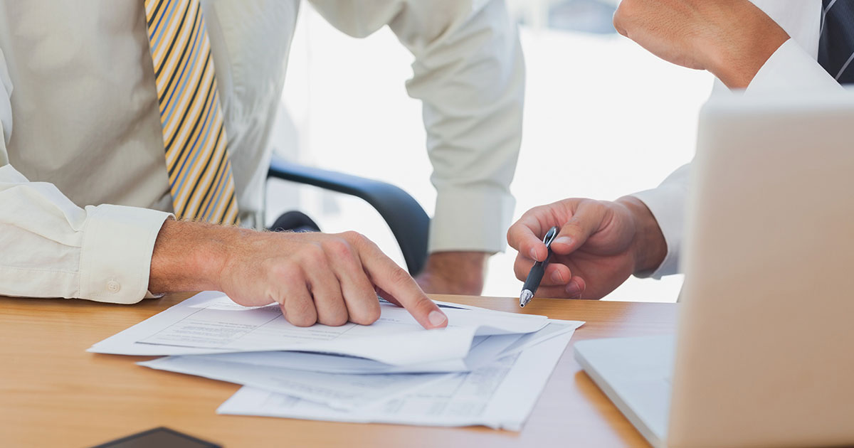 Two people calculating EBITDA for a dental practice. 
